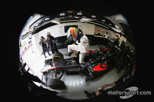 Fernando Alonso climbs from his car in the garage.